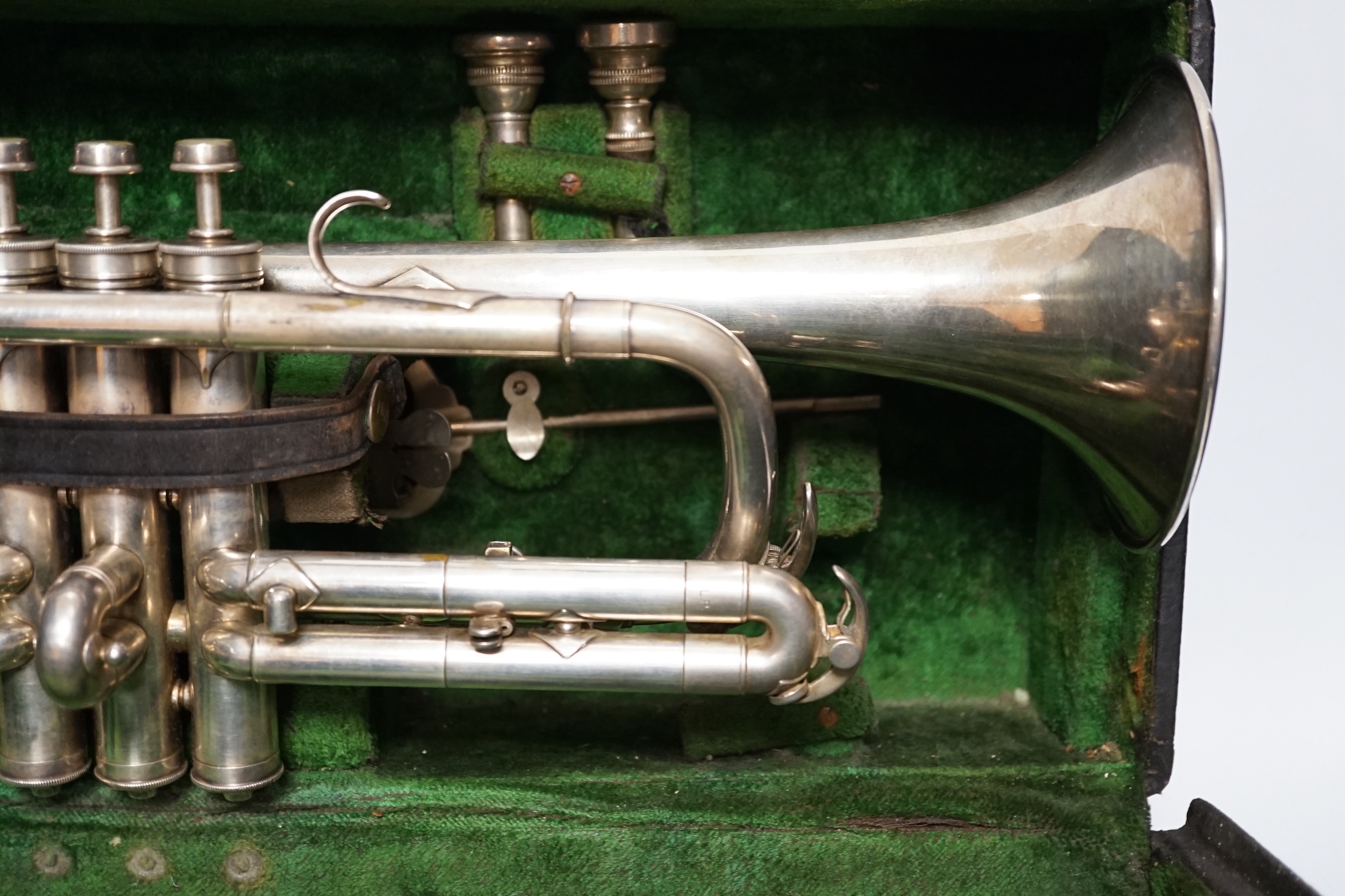 An Elkhart, Indiana No. 144989 trumpet, unusual trumpet with threaded fine adjust tuning slides, spare set of slides, two mouthpieces and two music lyres for marching, in a good fitted case, with a card boxed ‘maintenanc